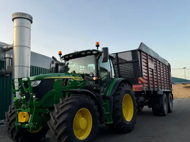 Traktor mit Anhänger an einer Biogasanlage in der Abenddämmerung