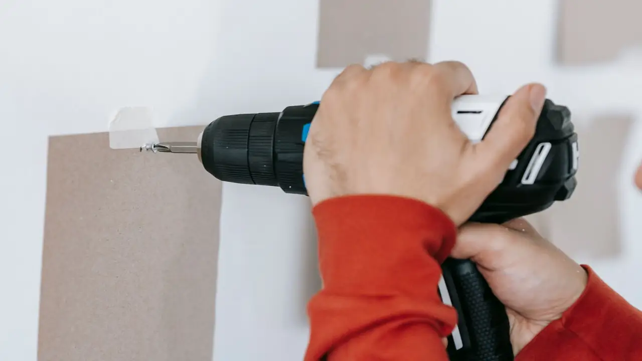 Handwerker verschraubt mit dem Akkuschrauber eine Fassadenverkleidung