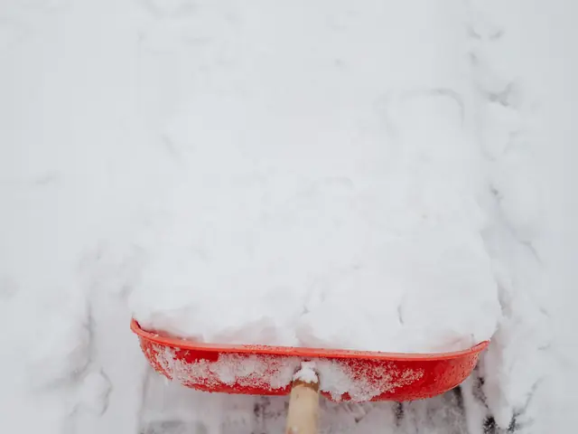 Schneeschieber räumt frischen Schnee von einer Fläche